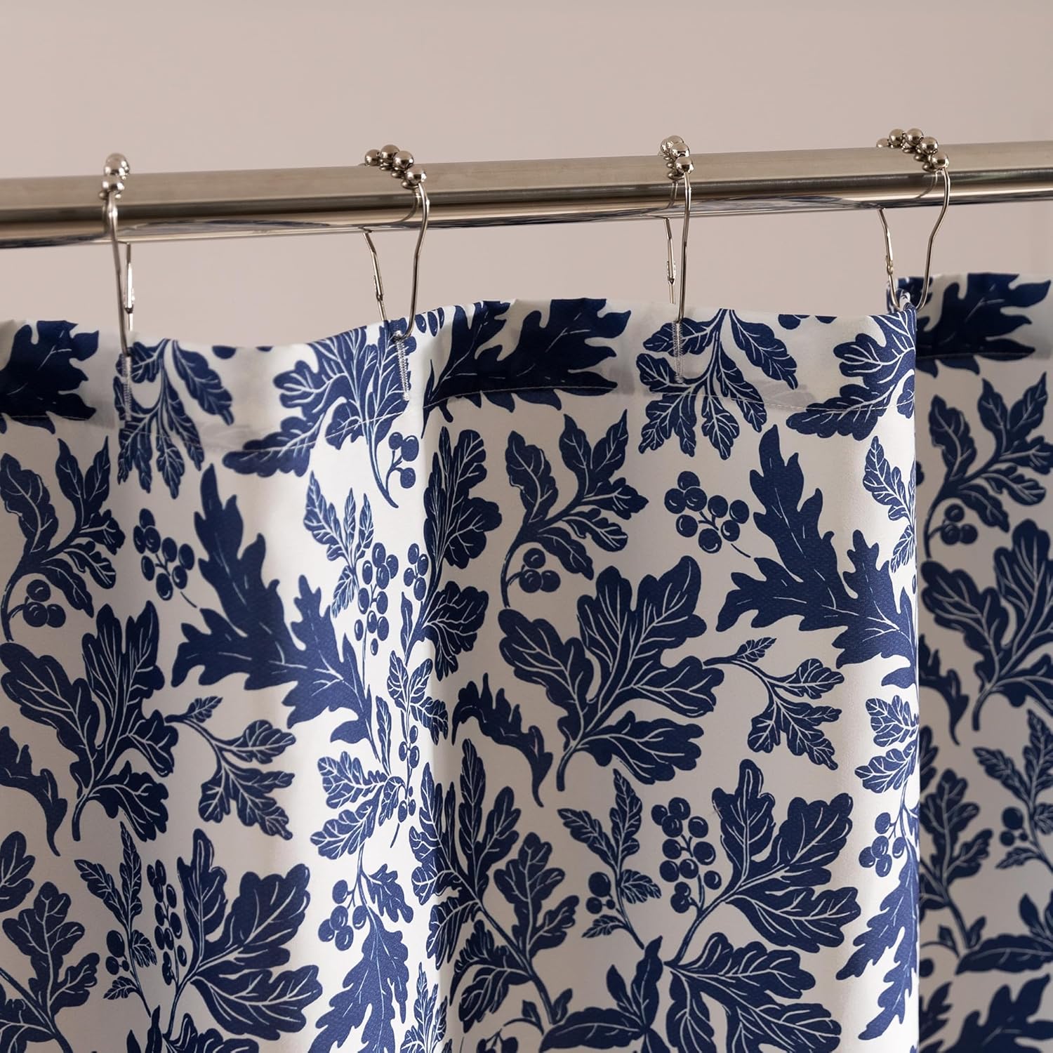 Blue floral patterned shower curtain on a rod against a beige wall